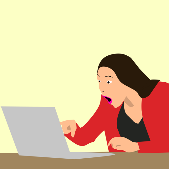 Oppspilt kvinne foran laptop