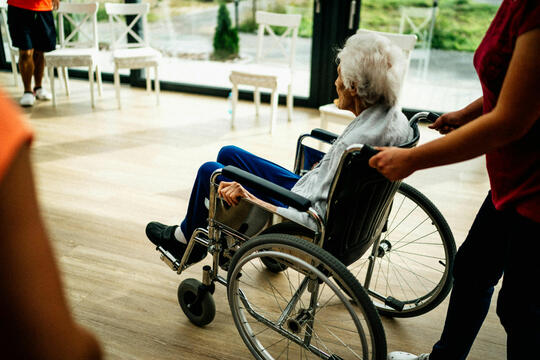 Gammel person i rullestol på sykehjem
